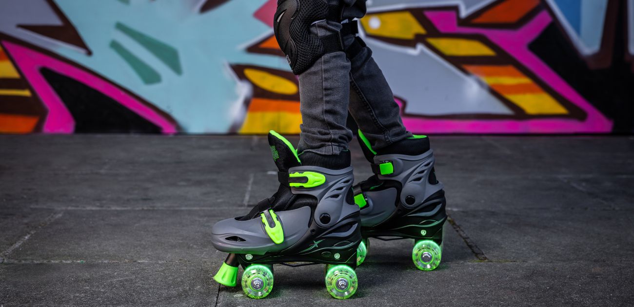 A photo of black and green quad skates with LED wheels against a graffiti background