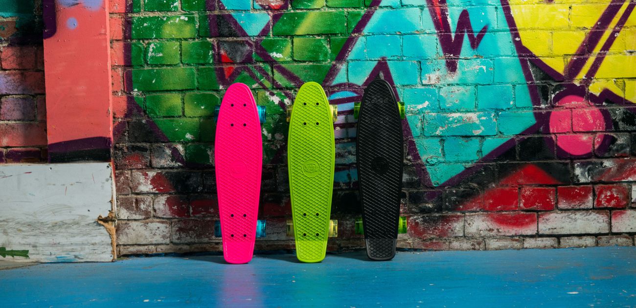 A photo of three cruiser skateboards against a graffiti background